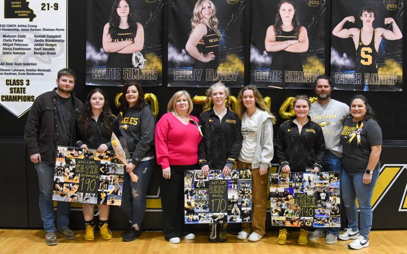 SENIOR NIGHT. Senior wrestlers Katie Summers, Ruby Daily and Dorie Richardson are pictured from left to right with their families. They sent their goodbyes to Sullivan in the ceremony and, afterward, to the Dragons. Photo by Extra Innings Photography Article Image Alt Text
