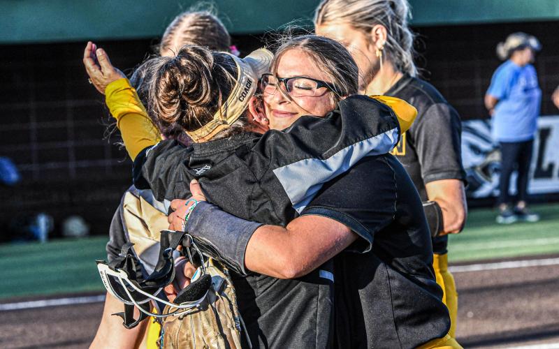HOLD ON. After winning the quarterfinal, Evvie Blankenship (right) hugs her mother, Heidi (left). Photo by Extra Innings Photography Article Image Alt Text