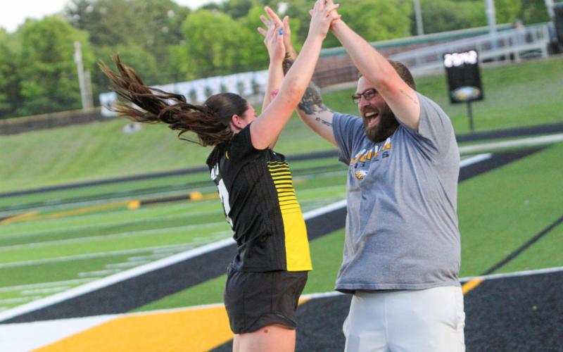 CELEBRATE GOOD TIMES. Chloe Carson (left) excitedly returns to the sideline and celebrates with Coach Matt O’Dell after scoring her first of the year. Photo by Wyatt Hardy Article Image Alt Text