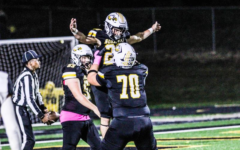 CELEBRATE GOOD TIMES. Nolan Center (70) lifted Mark Jennings (26) off the ground after a score. Photo by Wyatt Hardy Article Image Alt Text