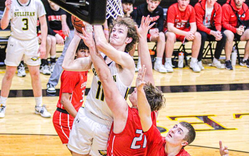 SETH VALLEY (11) soars over a pack of Tigers for a layup. He scored 5 points against St. James. Photo by Wyatt Hardy. Article Image Alt Text