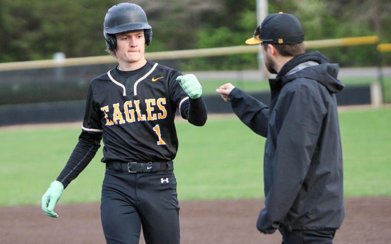 NATE McREYNOLDS (1) fist-bumps Kris Poore. Photo by Wyatt Hardy Article Image Alt Text