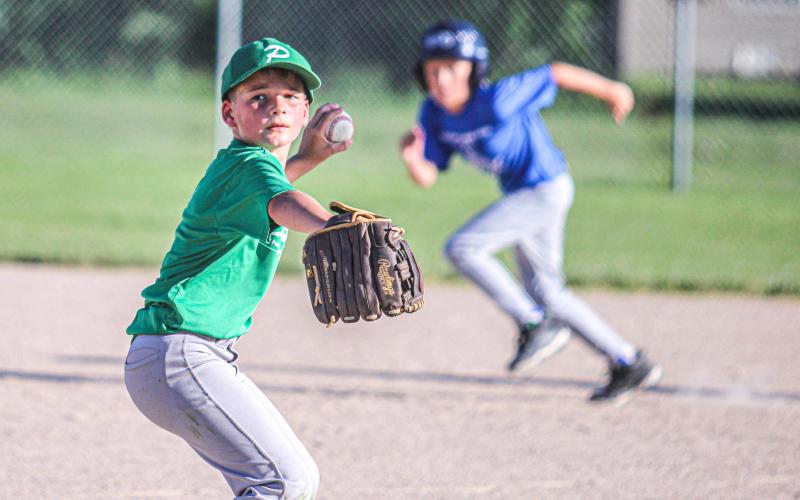 CAT AND MOUSE. Peoples Bank pitcher Dace gears up to throw while unaware that Sullivan Masonic runner Coen Kaufman is stealing third base. Photo by Wyatt Hardy Article Image Alt Text