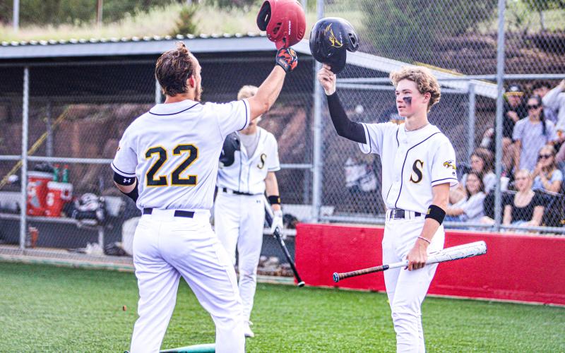 TIP OF THE CAP. Dayton Skaggs (left) homered and bumped helmets with Nolan Ulrich (right) once he returned to the dugout. Photo by Wyatt Hardy Article Image Alt Text