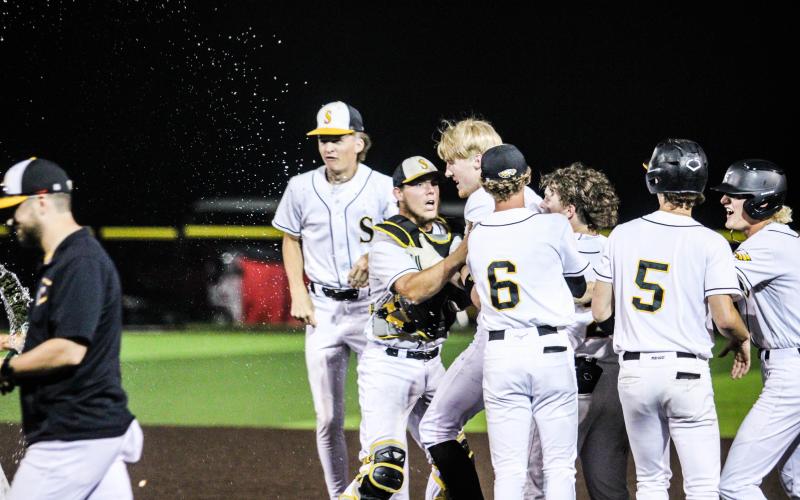 COMEBACK KID. The Eagles surround and cheer Drake Gawer after reeling in the game-winning RBI against Owensville. Photo by Wyatt Hardy Article Image Alt Text