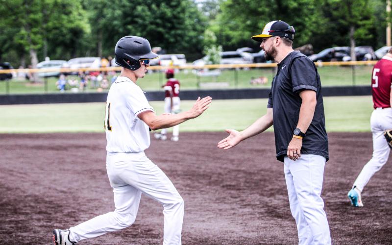 WIN THE BATTLE. Gavin Schmidt high-fives assistant coach Kris Poore. Photo by Wyatt Hardy Article Image Alt Text