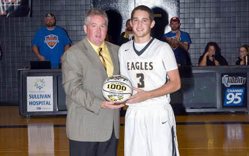 HITTING MILESTONES. Cody McKinney (left) is pictured with his father and head coach Dino (right) after eclipsing 1,000 career points in basketball against Farmington on Nov. 30, 2018. Photo by Extra Innings Photography Article Image Alt Text