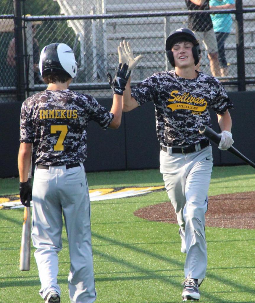 Garrett Juergens and Collin Immekus exchange high fives after Juergens scores in the first inning Friday