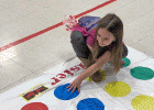 Kindergarten student, Alyssa trying to keep her balance on the Twister game board during the recent SJS K-4 event.