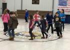 Students in grades K-4 at Strain-Japan School try to win a cupcake on the cupcake walk as STUCO member, Alexia plays music.